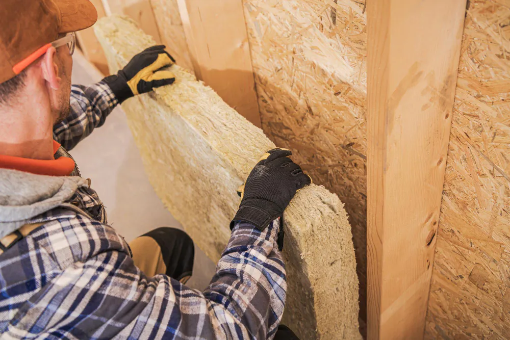 Technician handling old insulation batts